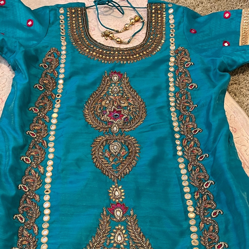 Blue suit with gold embroidery and pink accents. Real mirror work